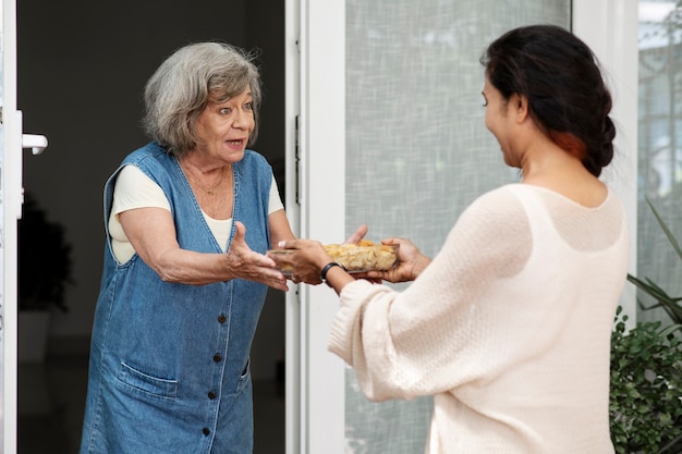 Woman offering food to neighbor
