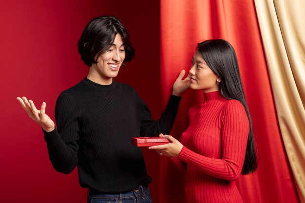 Женщина предлагает подарок мужчине на китайский Новый год