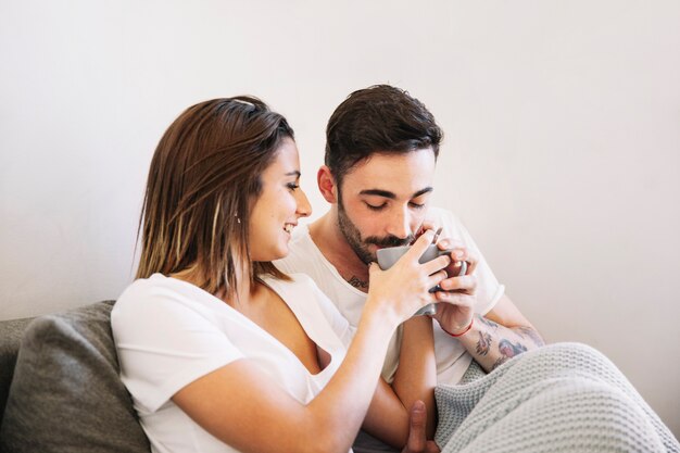 Woman offering man to taste beverage