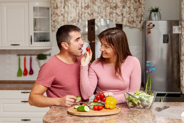 Женщина предлагает помидор своему парню