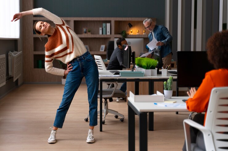 Free Photo woman at the office stretching during a work day