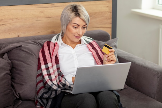 Женщина в офисе с ноутбуком и кредитной картой