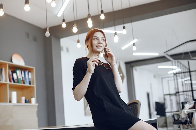 Woman at the office. Worker tallking. Lady in a black dress.