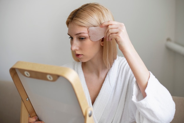 女性が進行中のグアシャ顔の手術