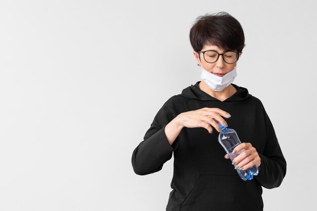 Бесплатное фото Женщина открывает бутылку воды с копией пространства