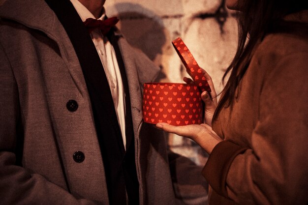 Woman opening gift box to man 