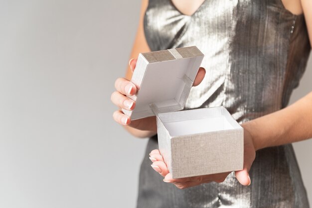 Woman opening silver wrapped gift