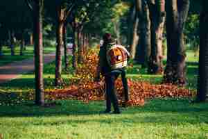 Free photo a woman operating a heavy duty leaf blower