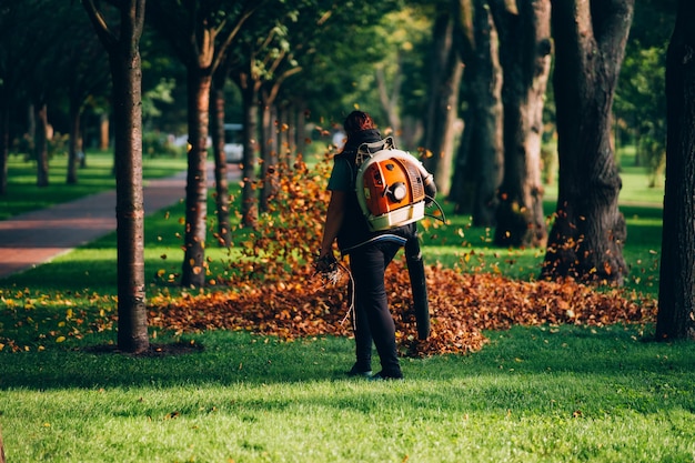 A woman operating a heavy duty leaf blower