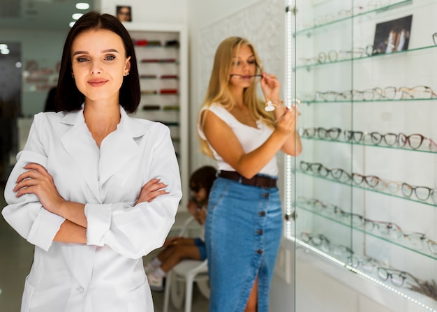 Woman and optician in eyeglasses frames shop