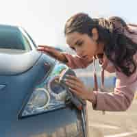 Foto gratuita donna all'aperto che pulisce l'automobile