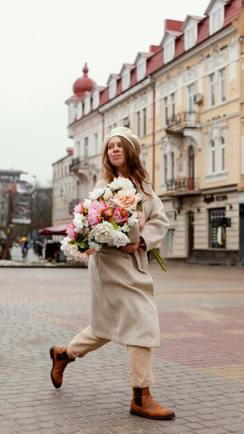 Женщина на открытом воздухе держит букет цветов весной