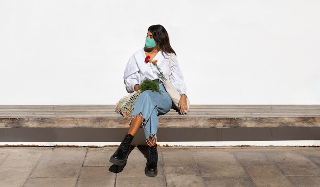 Woman outdoors with flowers and grocery bags