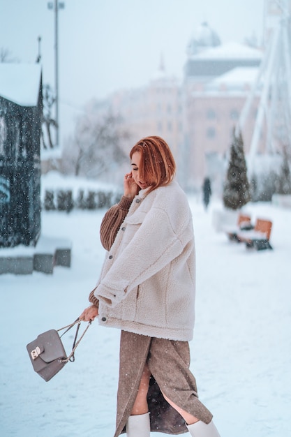 Woman outside on snowing cold winter day