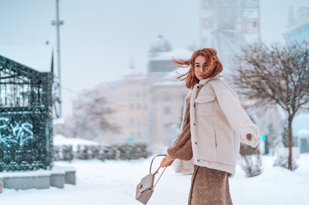 Woman outside on snowing cold winter day