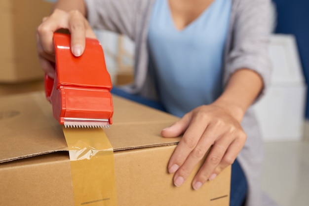 Woman Packing Box With Tape