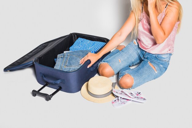Woman packing suitcase for trip