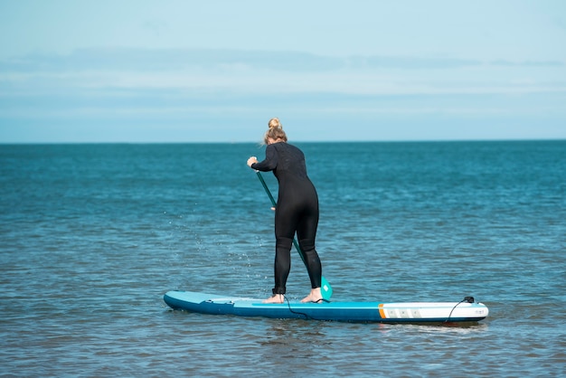 Woman paddleboarding full shot