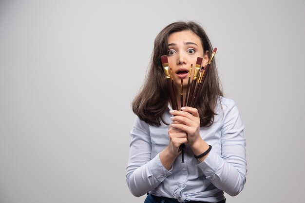 Foto gratuita pittore della donna che tiene i pennelli e si sente premuroso.