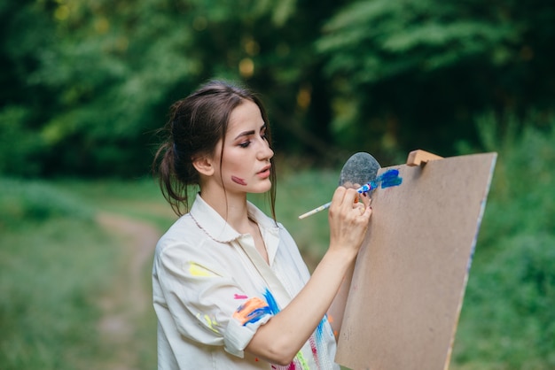 Woman painting on a brown surface