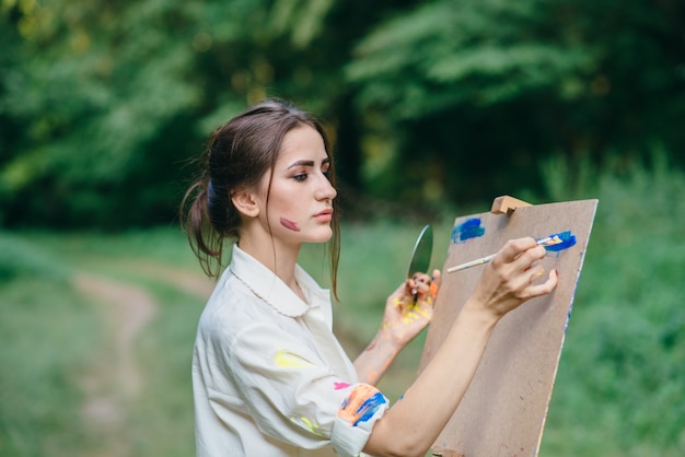 Free photo woman painting on a brown surface