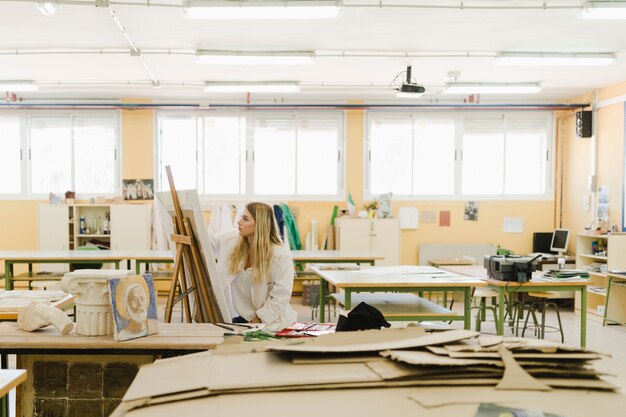 Woman painting on easel in the workshop