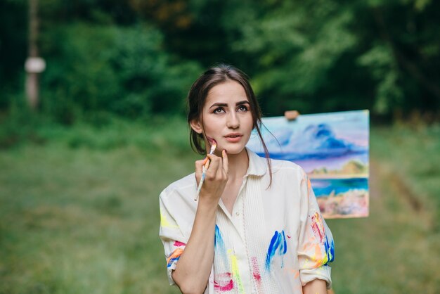 Woman painting her face with a paint brush