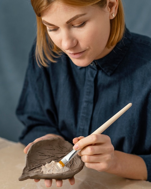 Woman painting leaf close-up