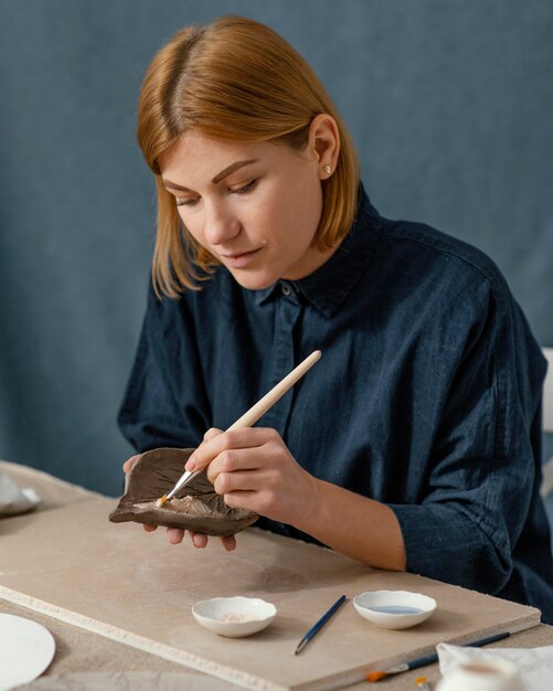 Woman painting leaf medium shot