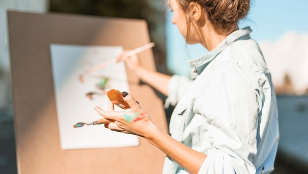 Free photo woman painting outdoors