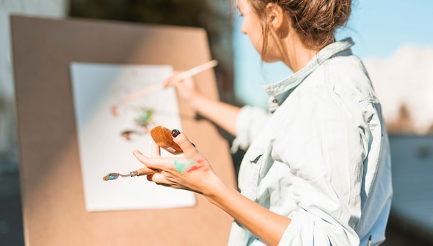 Женщина рисует на открытом воздухе