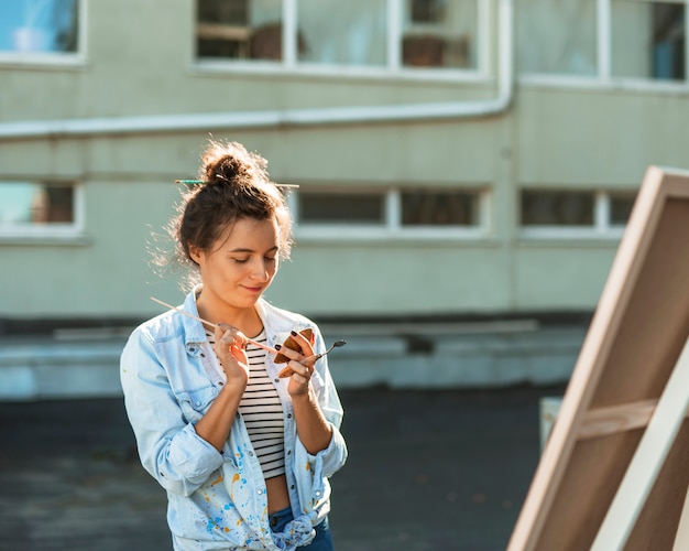 Free photo woman painting outdoors