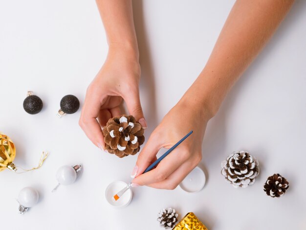 Woman painting pine cone for decorations