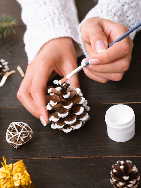 Woman painting a pine cone