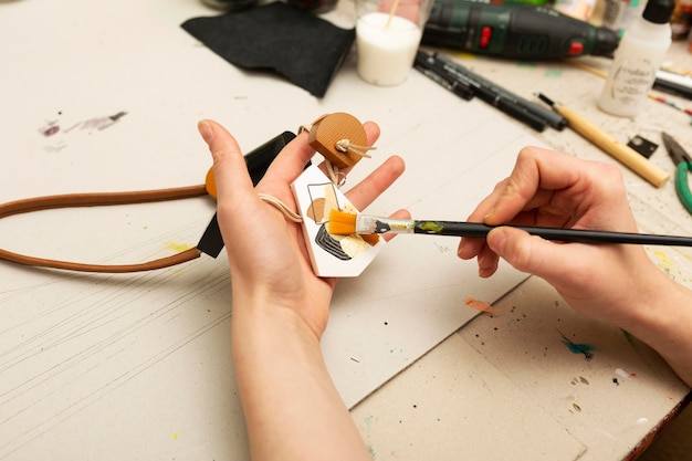 Free photo woman painting a small piece of wood