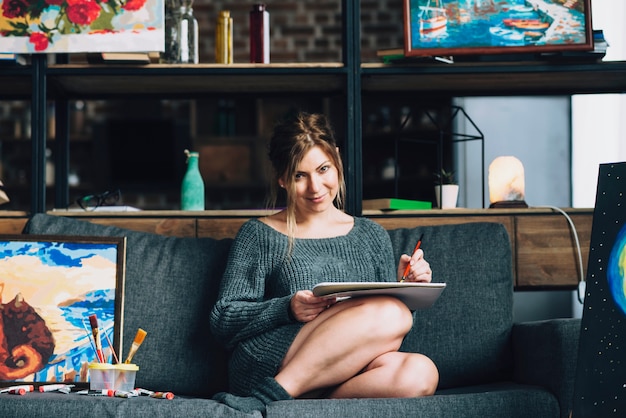 Woman painting on sofa