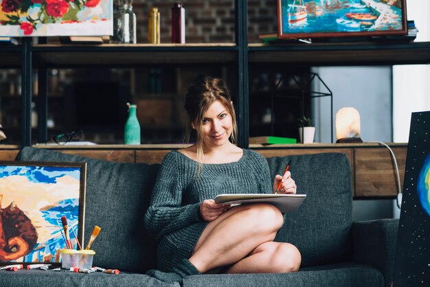 Woman painting on sofa