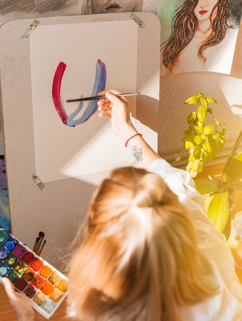 Free photo woman painting with watercolor in studio