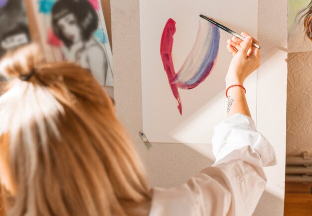 Woman painting with watercolor in studio