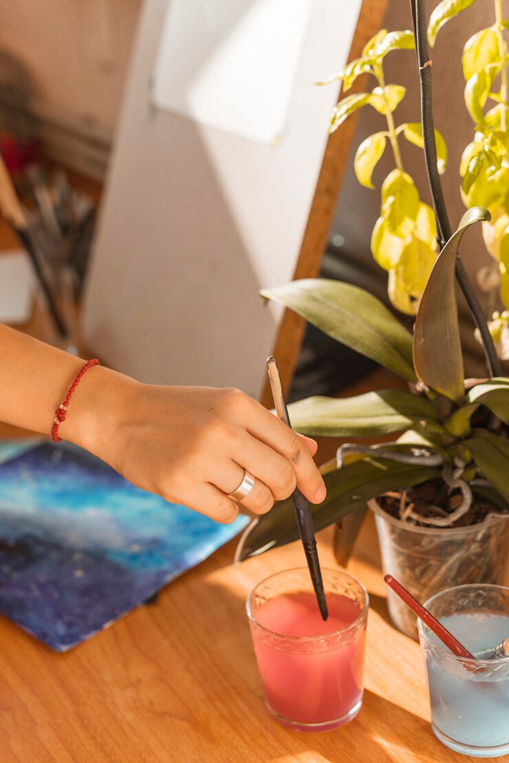 Free Photo woman painting with watercolor in studio