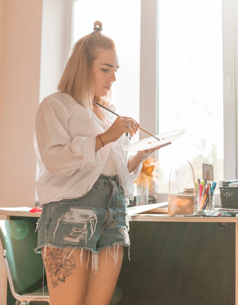 Foto gratuita pittura della donna con acquerello in studio