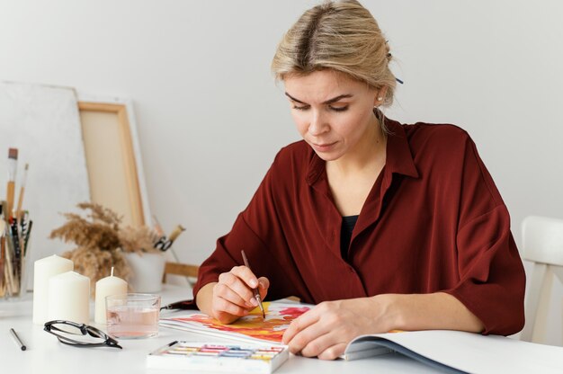 Woman painting with watercolors on paper