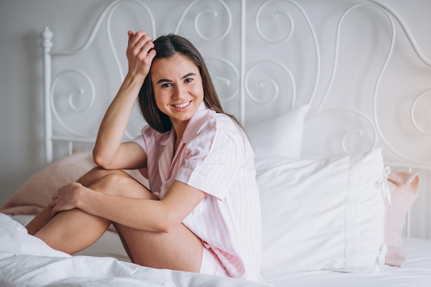 Free photo woman in pajamas sitting in bed