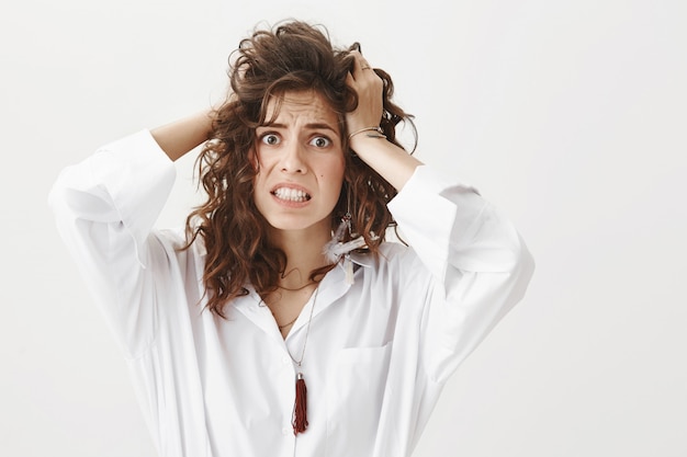 Woman in panic toss hair and stare scared