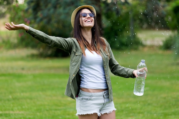 Free photo woman in park with bottle of water