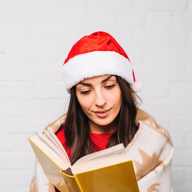 Woman in party hat reading book