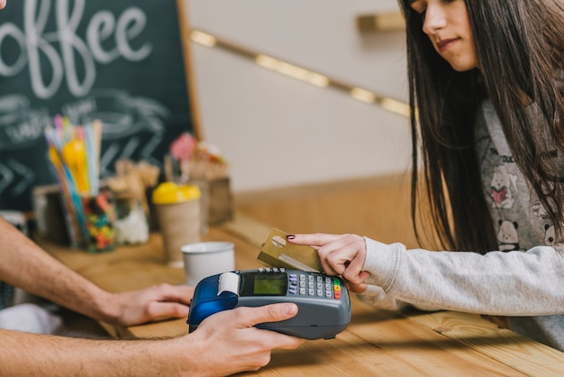 Foto gratuita donna che paga con carta di credito nella caffetteria