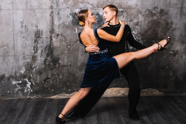 Женщина выполняет раскол во время страстного танца партнера