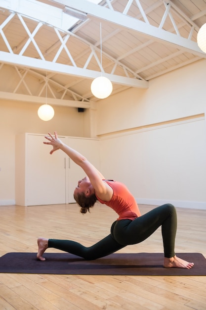 Woman performing stretching exercise on exercise mat