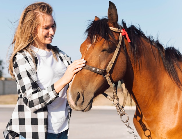 Free photo woman petting adorable horse